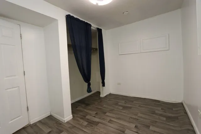 an empty room with wooden floor and white wall