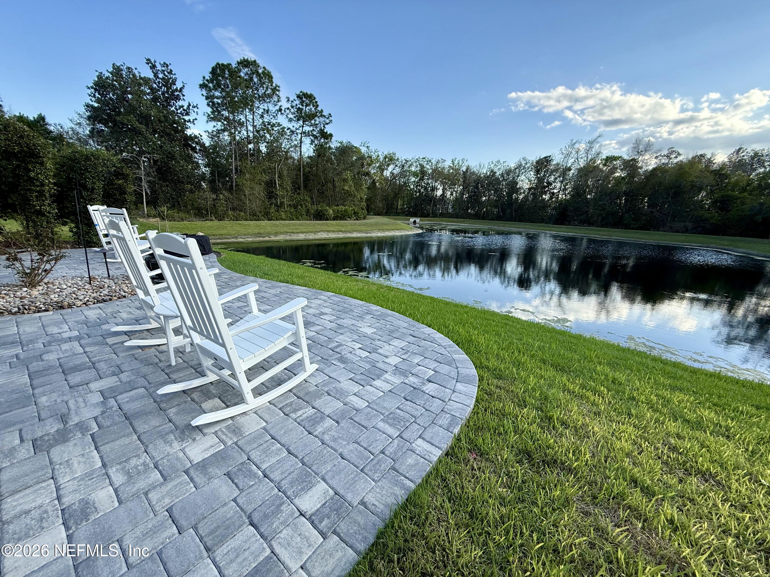 a view of a lake with table and chairs