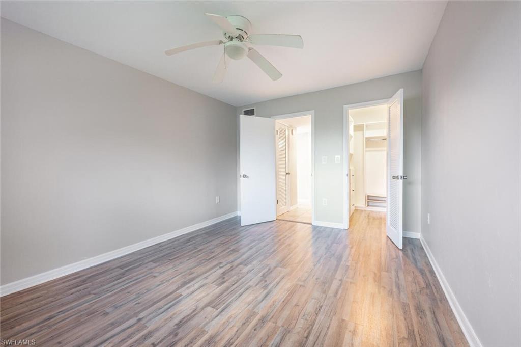100 Forest Lakes Boulevard, Unit 305 Naples, FL 34105 - Photo 11 of 31 Unfurnished bedroom with hardwood / wood-style floors and ceiling fan