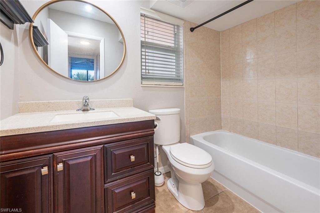 100 Forest Lakes Boulevard, Unit 305 Naples, FL 34105 - Photo 12 of 31 Full bathroom with tiled shower / bath, vanity, toilet, and tile patterned floors