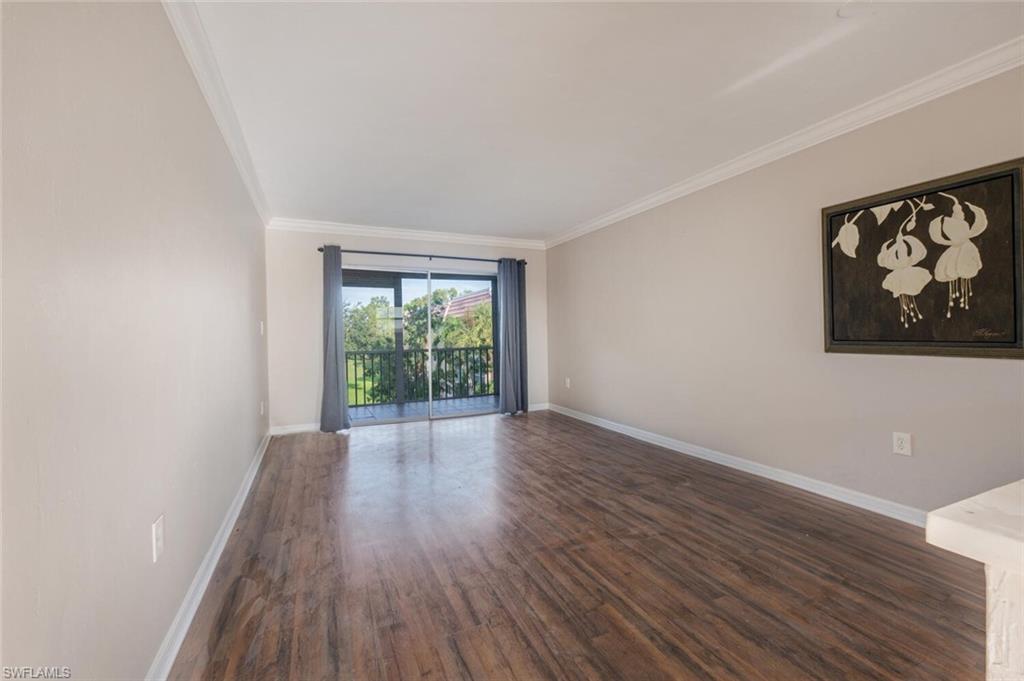 100 Forest Lakes Boulevard, Unit 305 Naples, FL 34105 - Photo 3 of 31 Unfurnished room with ornamental molding and dark hardwood / wood-style flooring