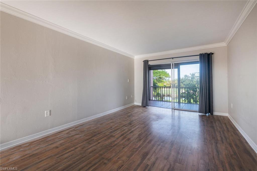 100 Forest Lakes Boulevard, Unit 305 Naples, FL 34105 - Photo 4 of 31 Unfurnished room with ornamental molding and dark hardwood / wood-style flooring