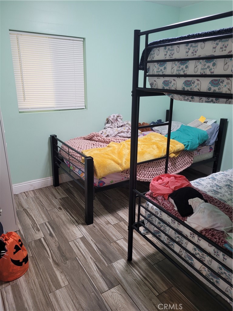 3833 1/2 Olive Street Huntington Park, CA 90255 - Photo 6 of 8 a bedroom with a bed and wooden floor