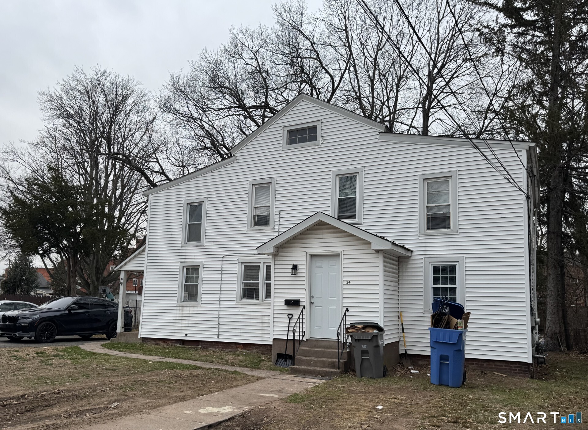 34-36 Cottage Street Manchester, CT 06040 - Photo 3 of 40 a view of a white house with a large tree and wooden fence