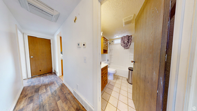 1348 Sagewood Road Price, UT 84501 - Photo 20 of 34 Corridor with cooling unit, a textured ceiling, and light wood-type flooring