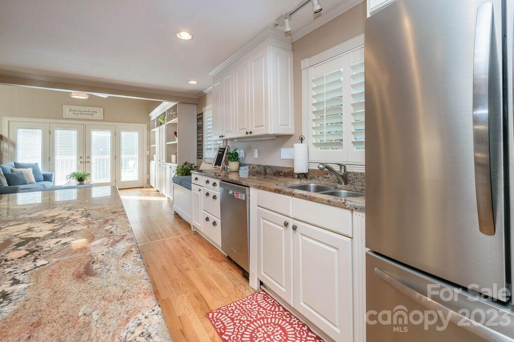 154 Rugby Drive Hendersonville, NC 28791 - Photo 16 of 48 a large kitchen with kitchen island granite countertop a refrigerator a sink a stove and white cabinets