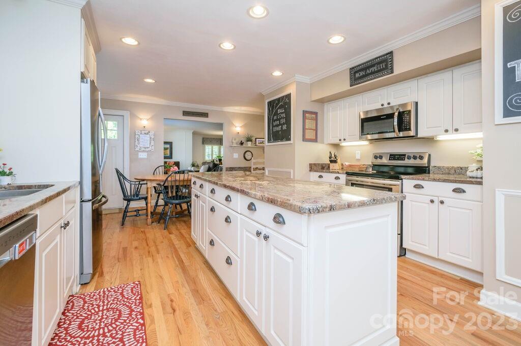 154 Rugby Drive Hendersonville, NC 28791 - Photo 18 of 48 a kitchen with stainless steel appliances kitchen island granite countertop a sink and cabinets
