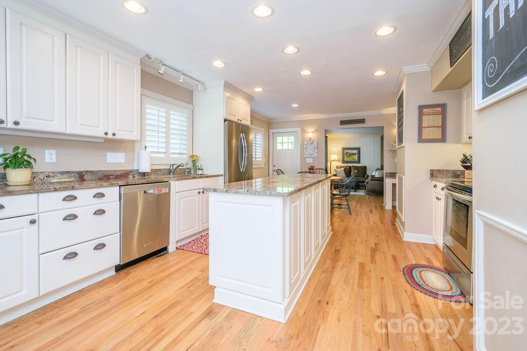 154 Rugby Drive Hendersonville, NC 28791 - Photo 19 of 48 a large kitchen with stainless steel appliances lots of counter space and wooden floors