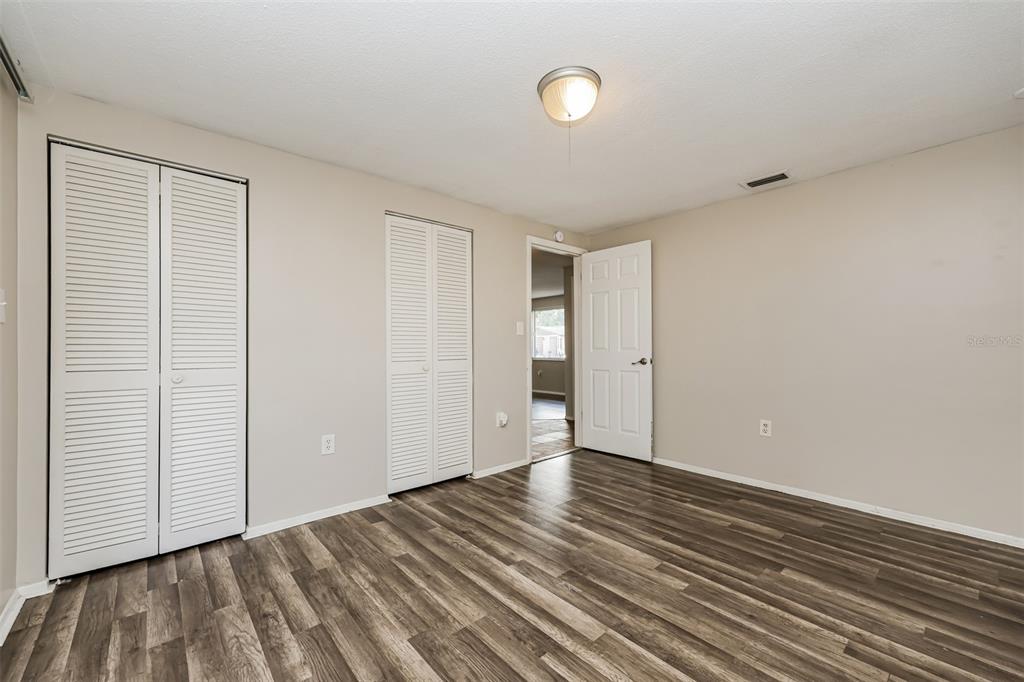 9436 Legend Lane Port Richey, FL 34668 - Photo 16 of 21 a view of an empty room with wooden floor and a window