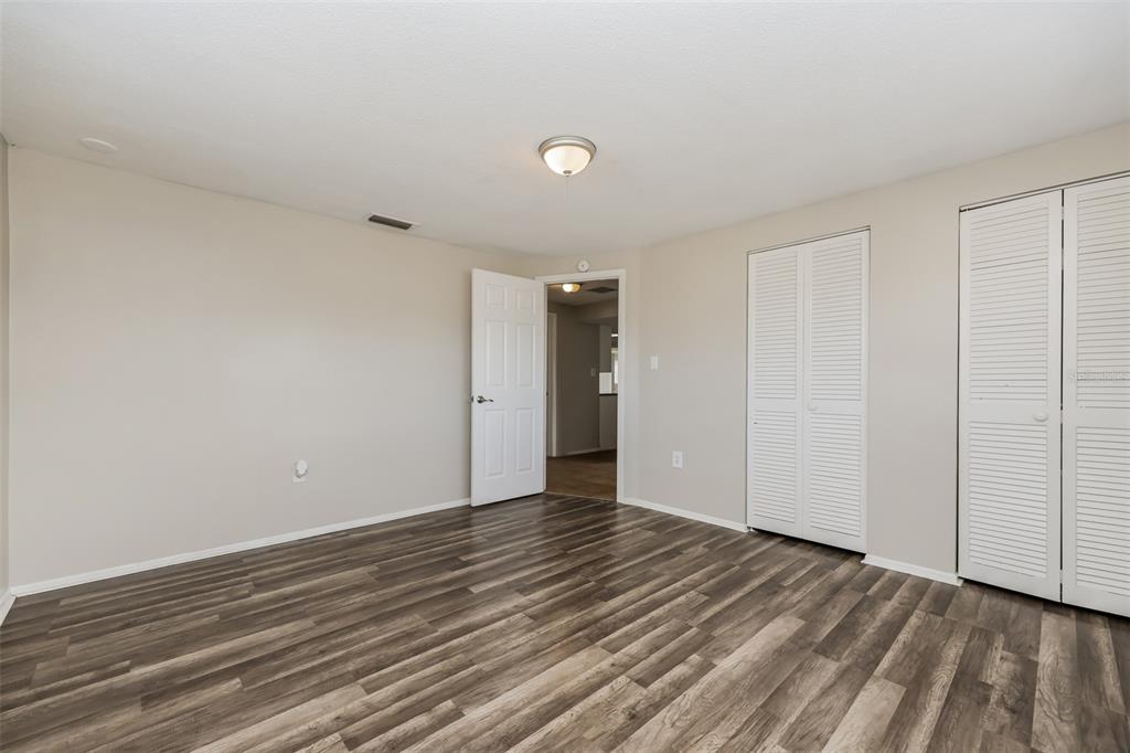 9436 Legend Lane Port Richey, FL 34668 - Photo 17 of 21 a view of an empty room with wooden floor and closet