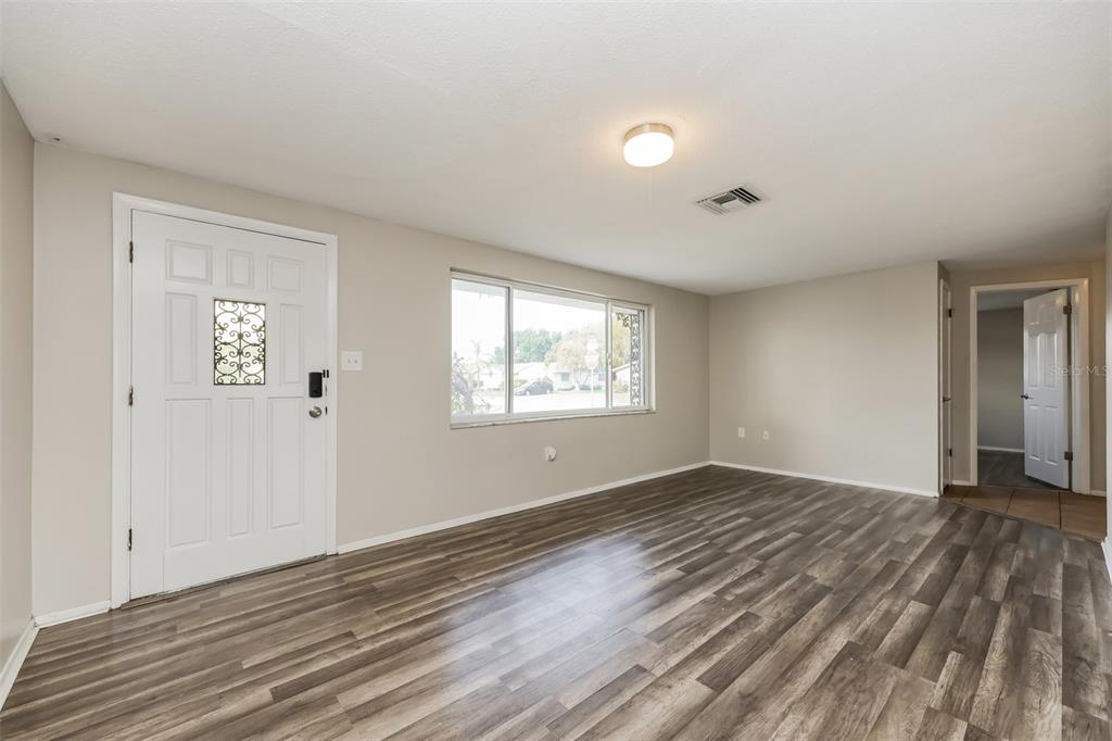 9436 Legend Lane Port Richey, FL 34668 - Photo 4 of 21 a view of an empty room with wooden floor and a window