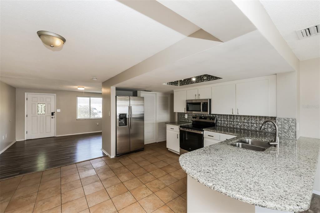 9436 Legend Lane Port Richey, FL 34668 - Photo 9 of 21 a kitchen with stainless steel appliances granite countertop a sink stove and refrigerator