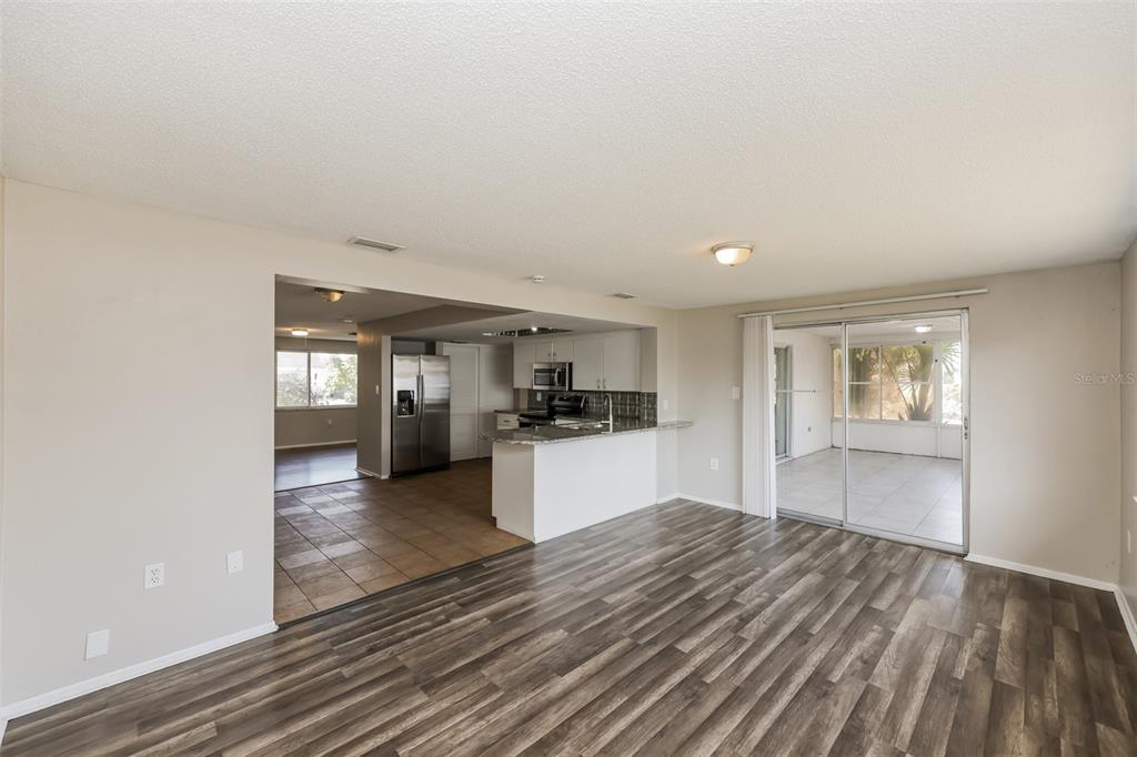 9436 Legend Lane Port Richey, FL 34668 - Photo 10 of 21 a view of a kitchen with wooden floor and a refrigerator
