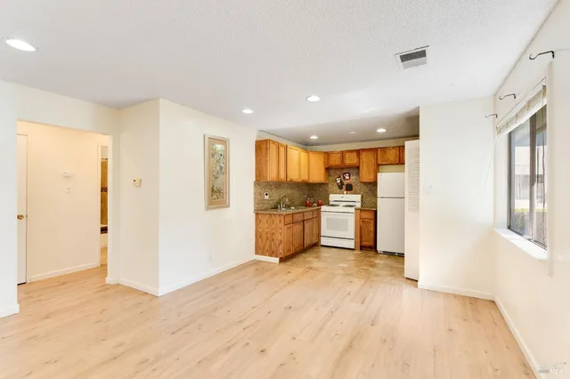 a view of a kitchen with a sink and a refrigerator