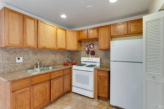 a kitchen with a refrigerator sink and cabinets