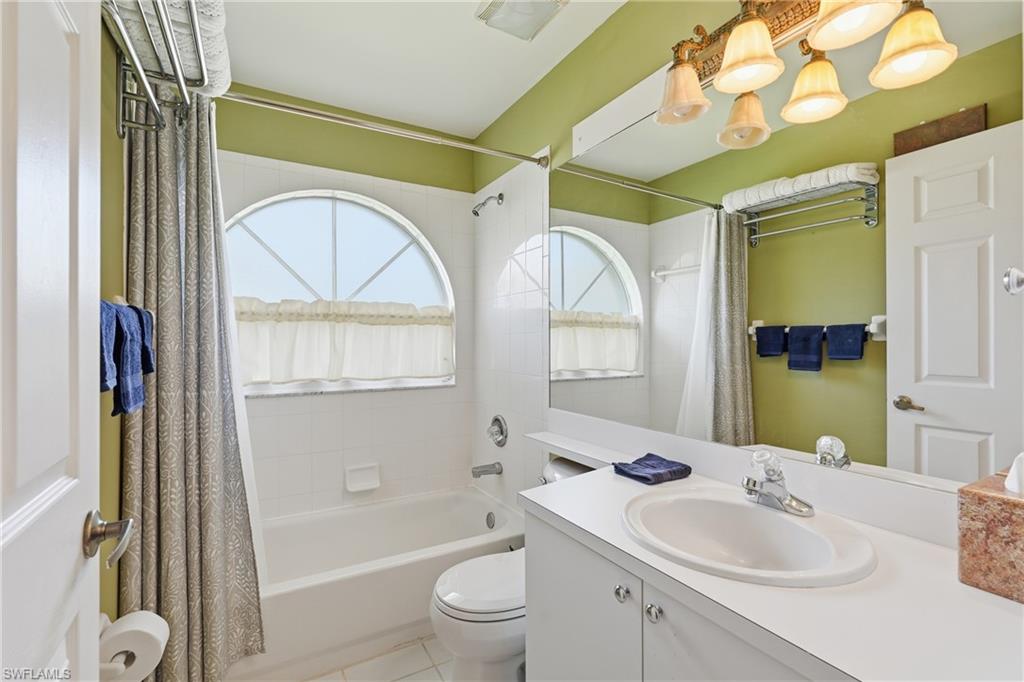 8055 Tiger Cove, Unit 608 Naples, FL 34113 - Photo 12 of 21 a bathroom with a sink a toilet and a mirror
