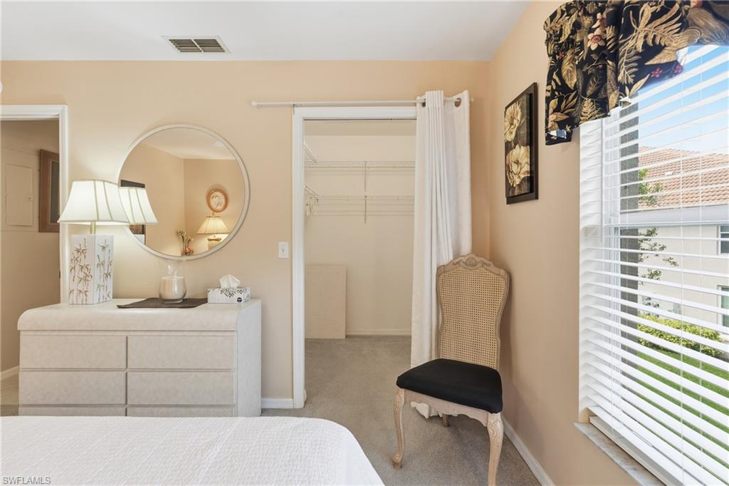 8055 Tiger Cove, Unit 608 Naples, FL 34113 - Photo 14 of 21 a bedroom with a bed and dresser with mirror