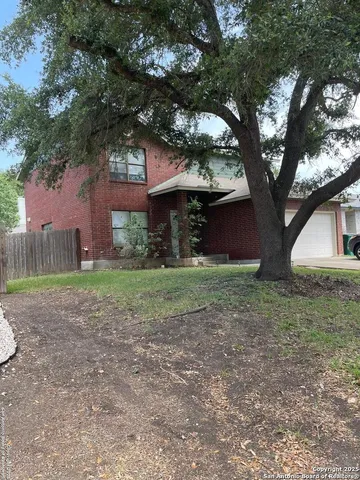 a view of a house with yard and a tree