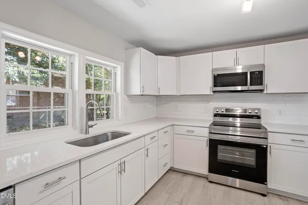 a kitchen with white cabinets and stainless steel appliances