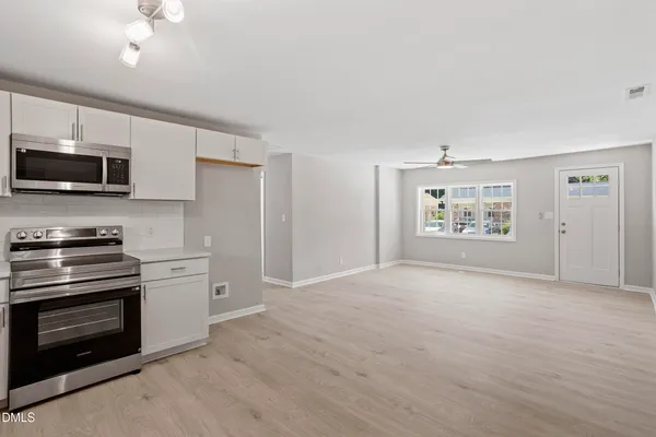 a view of kitchen with kitchen island a sink and a stove top oven