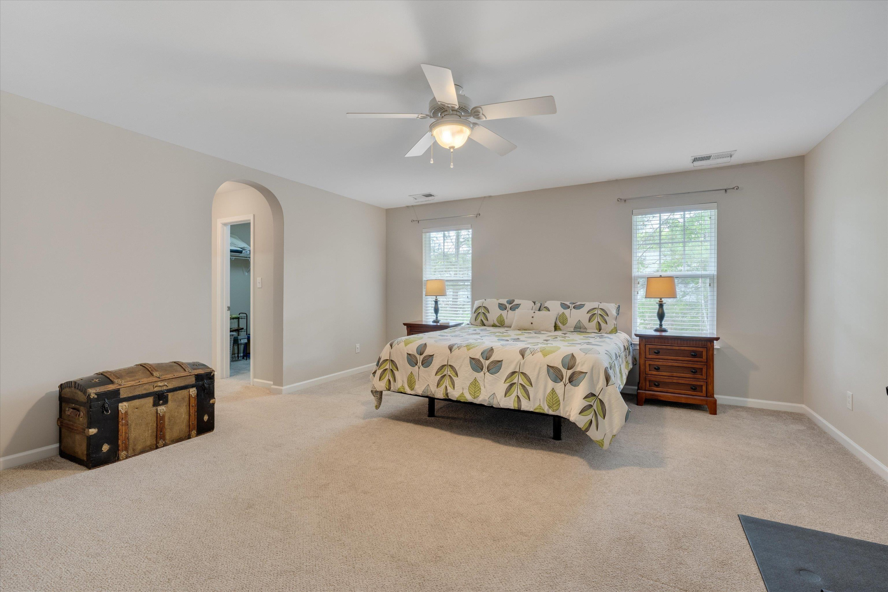 5 Gardenview Place Durham, NC 27713 - Photo 19 of 32 a bed sitting in a spacious bedroom next to a window and a chandelier