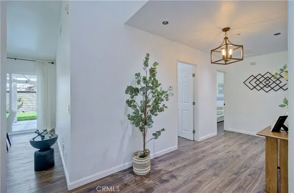 a view of a hallway with wooden floor and a chandelier