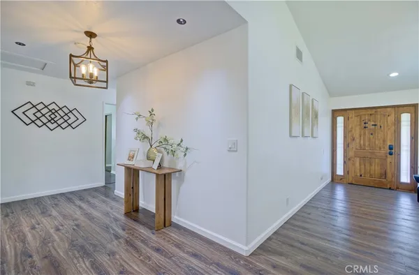 a view of a room with wooden floor and hallway