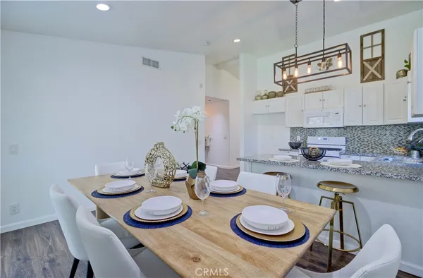 a kitchen with stainless steel appliances a table and chairs in it