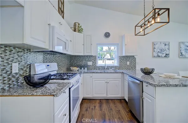a kitchen with stainless steel appliances granite countertop a sink stove and cabinets