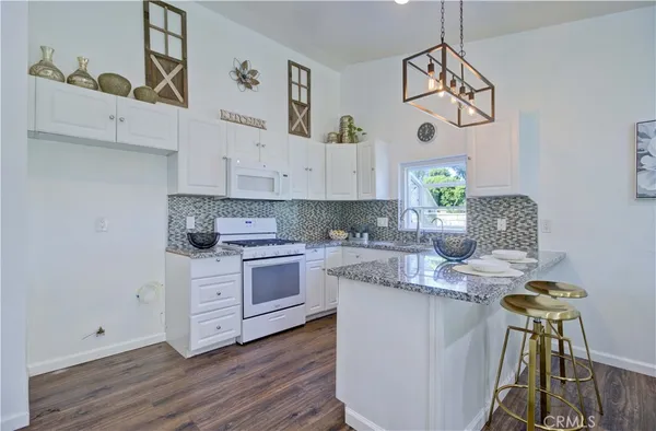 a kitchen with cabinets wooden floor and a window