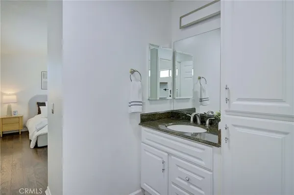 a en suite bathroom with a granite countertop sink and a mirror