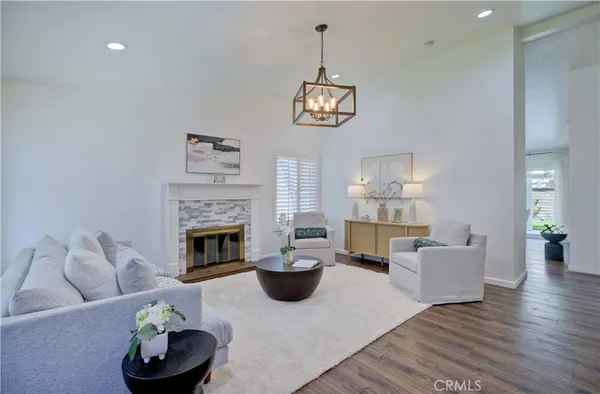 a living room with furniture a fireplace and a chandelier