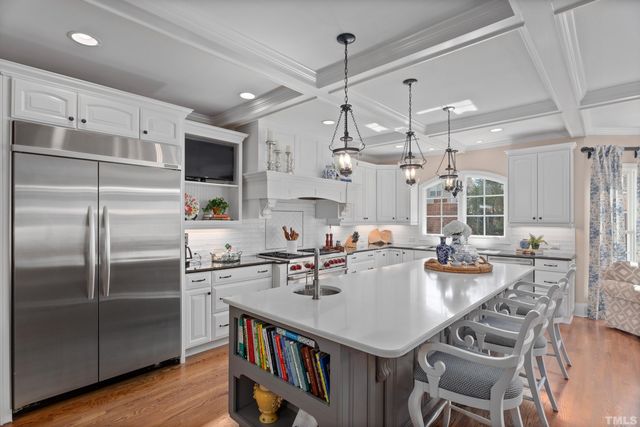a kitchen with a center island and stainless steel appliances