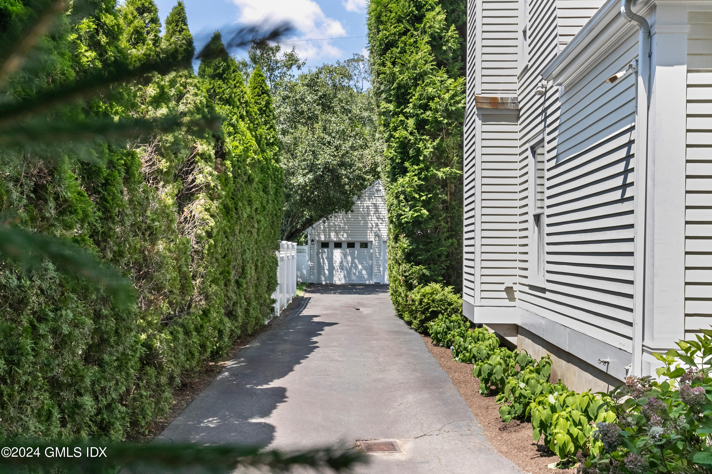 107 Summit Road Riverside, CT 06878 - Photo 37 of 47 a view of a pathway with a house in the background with potted plants