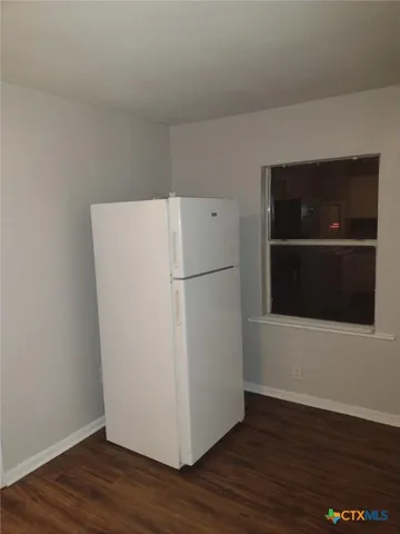 a view of a refrigerator in wooden floor