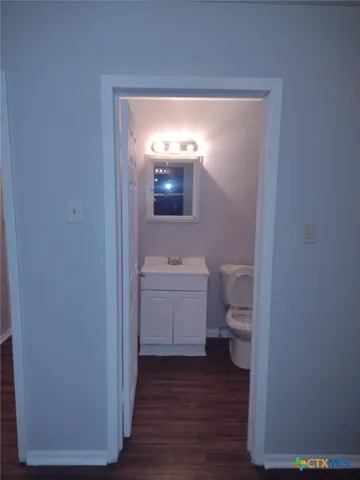 a bathroom with a toilet a sink and mirror
