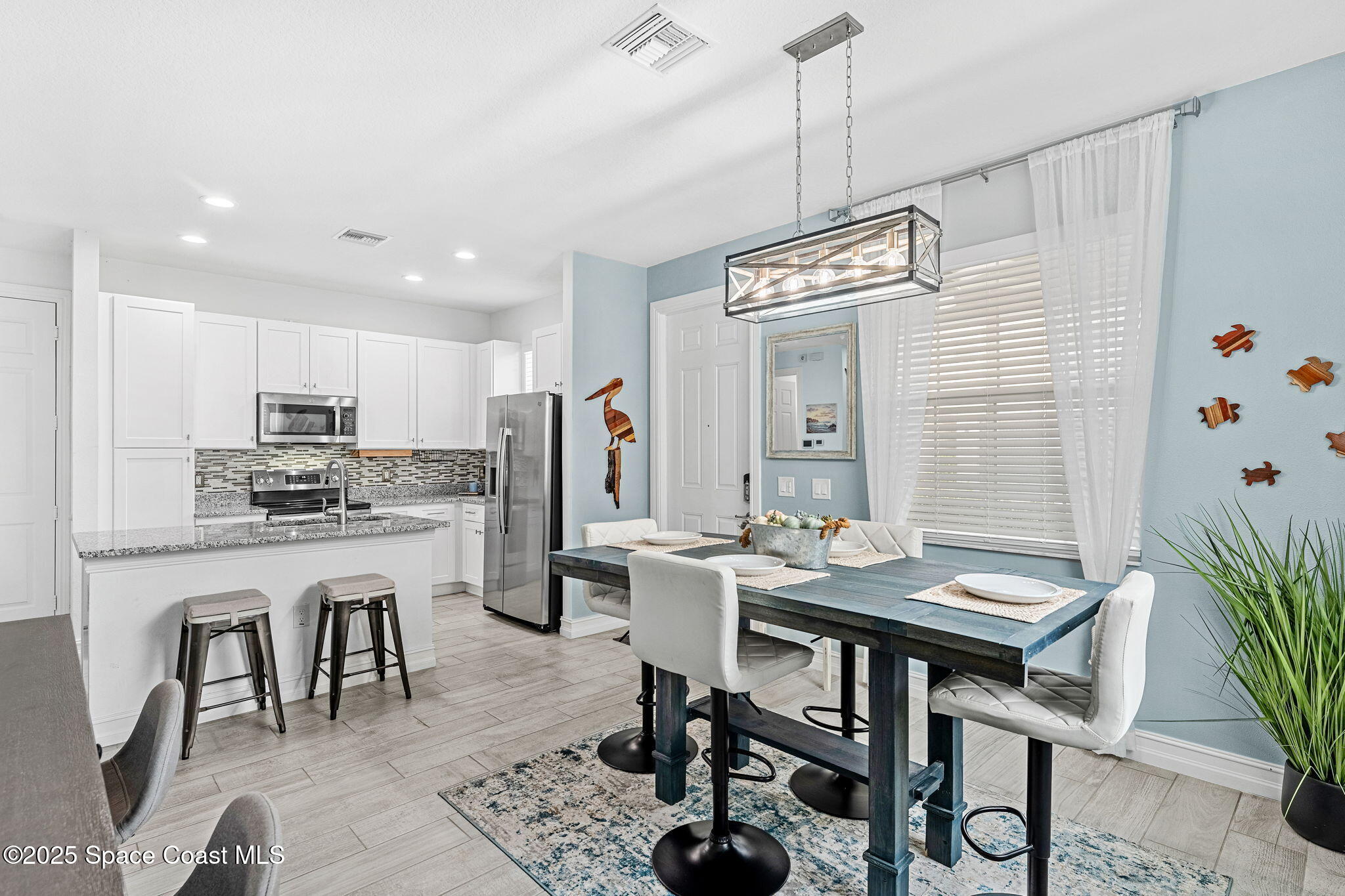 1810 Noel Place, Unit 107 Melbourne, FL 32935 - Photo 15 of 59 a kitchen with a dining table chairs stainless steel appliances and cabinets