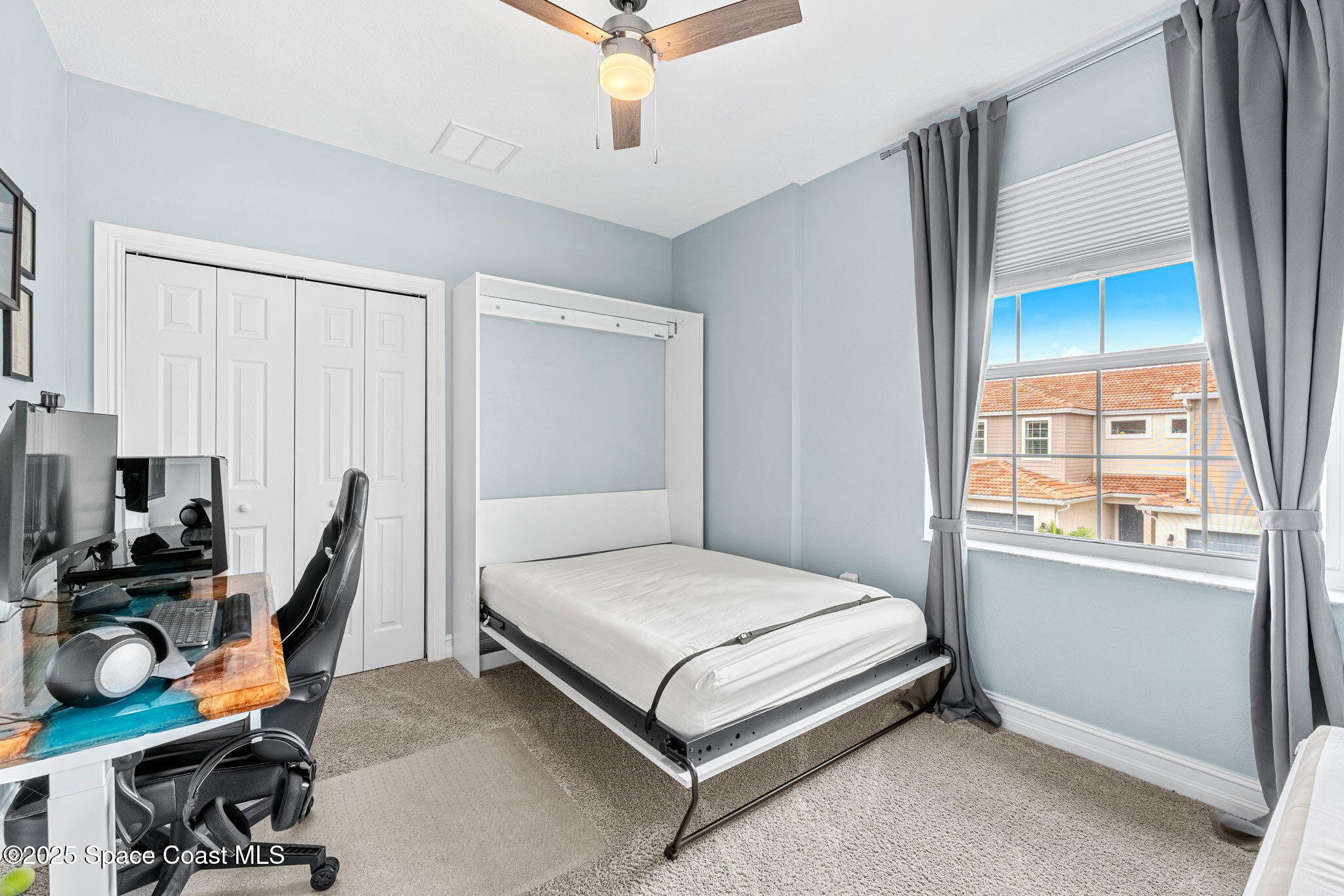 1810 Noel Place, Unit 107 Melbourne, FL 32935 - Photo 33 of 59 a bedroom with a bed a table and a chandelier