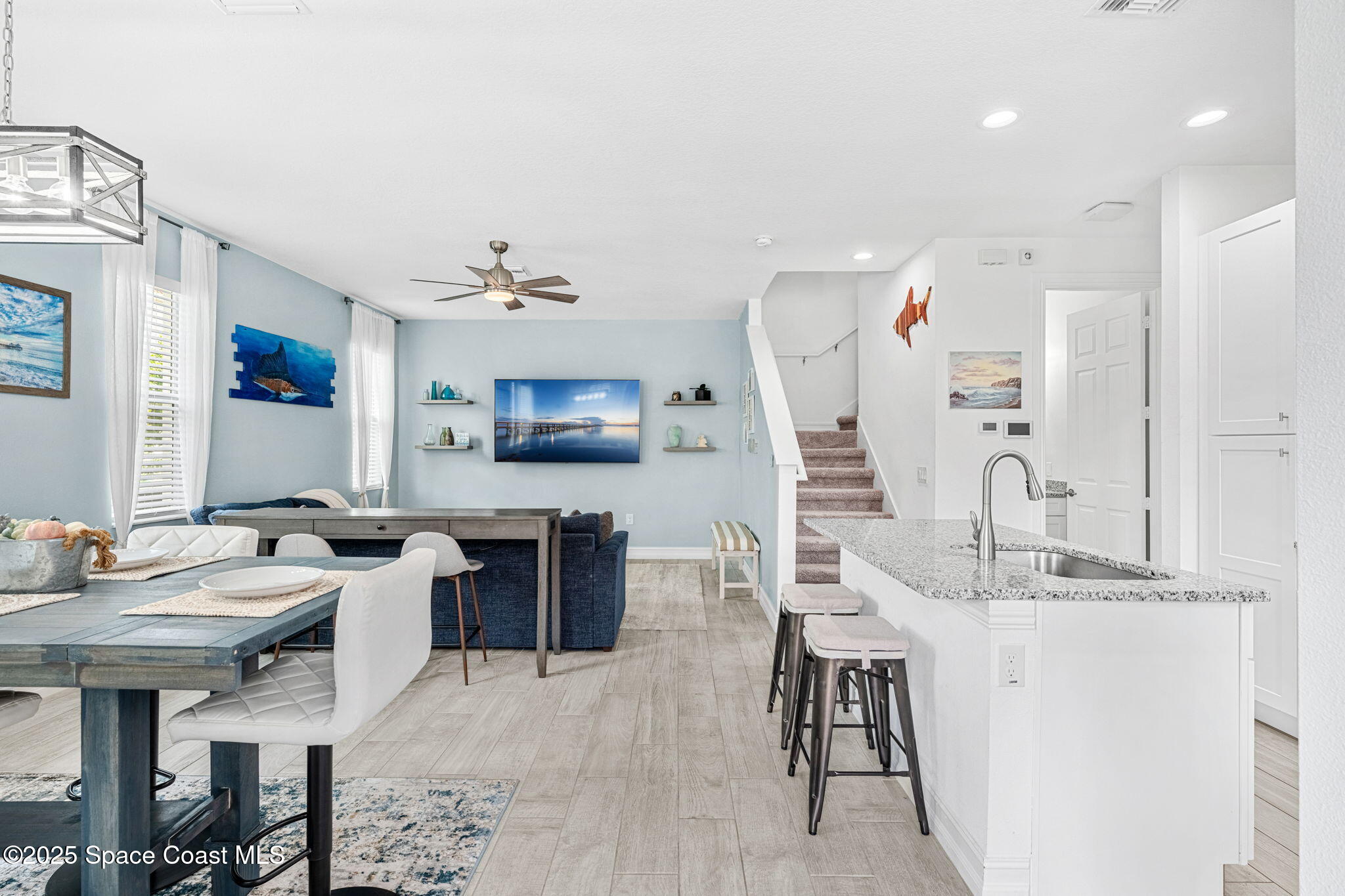 1810 Noel Place, Unit 107 Melbourne, FL 32935 - Photo 7 of 59 a living room with furniture a flat screen tv and kitchen view