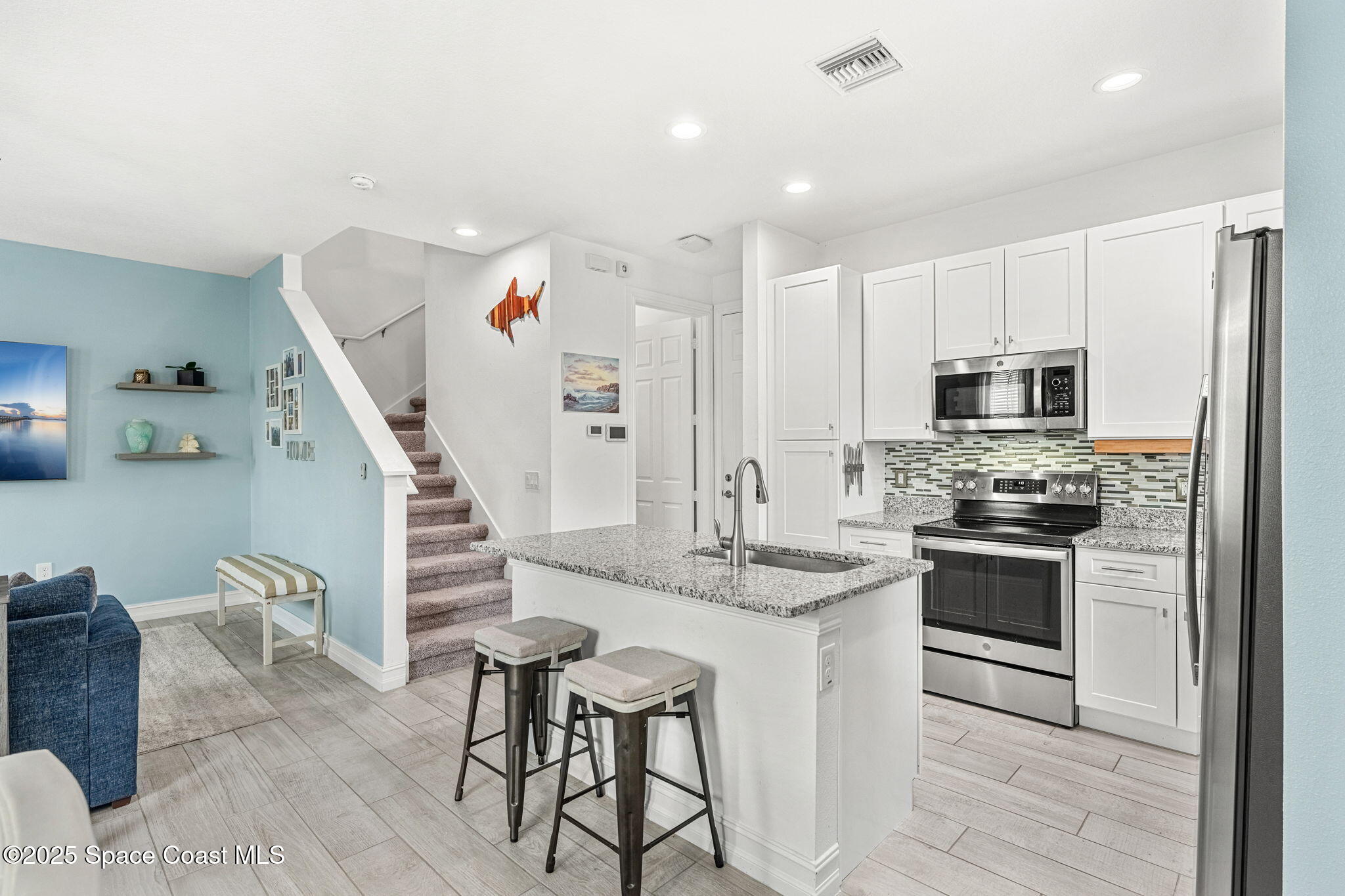1810 Noel Place, Unit 107 Melbourne, FL 32935 - Photo 8 of 59 a kitchen with granite countertop a stove a sink and a refrigerator