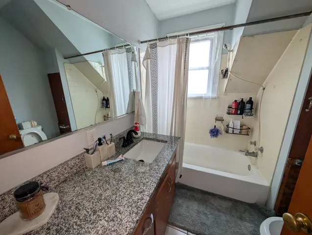 a bathroom with a tub sink and mirror