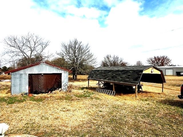 1525 Mansfield Road Reno, TX 75462 - Photo 26 of 34 a backyard of a house with table and chairs under an umbrella