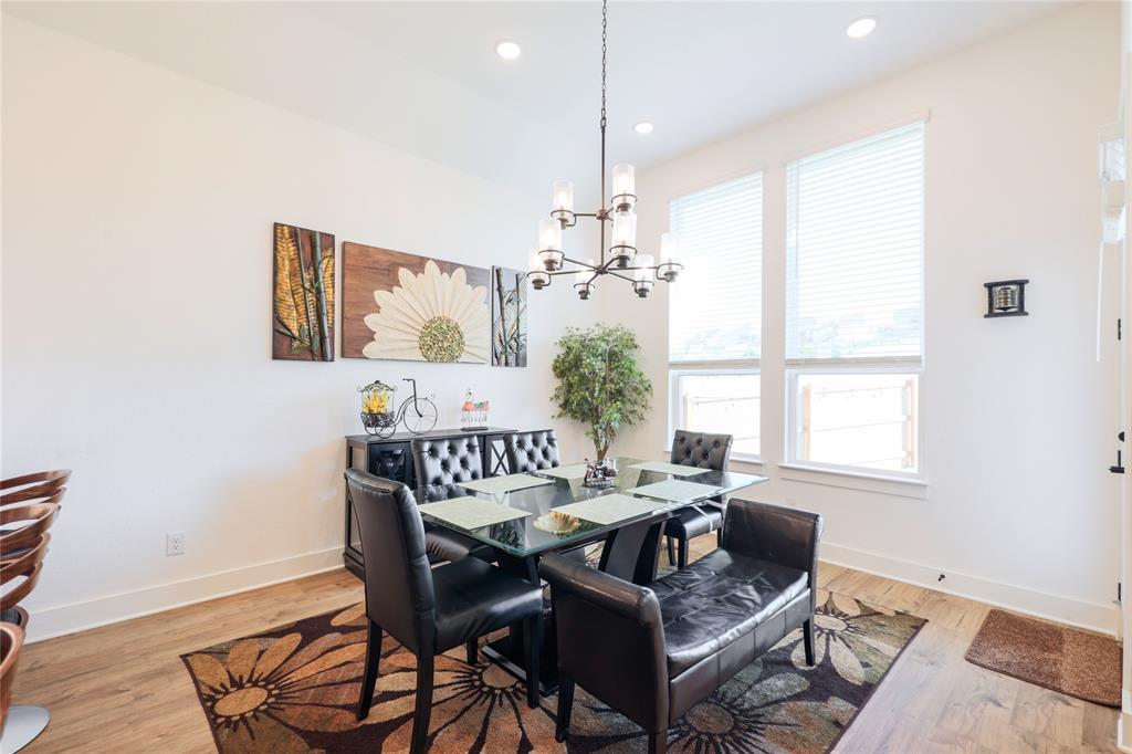 916 Willie Rnch Way Leander, TX 78641 - Photo 11 of 38 Dining area featuring light wood flooring and white walls, with two large windows providing natural light