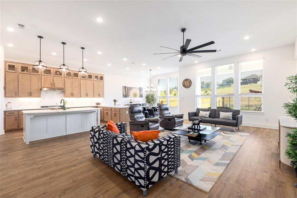 916 Willie Rnch Way Leander, TX 78641 - Photo 17 of 38 Spacious open concept living area featuring hard surface flooring, a modern kitchen with a large island and ample cabinetry, recessed lighting, and expansive windows
