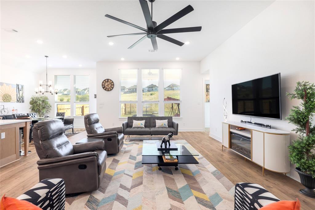 916 Willie Rnch Way Leander, TX 78641 - Photo 18 of 38 The living area features light-colored flooring, a ceiling fan, and recessed lighting, with large windows providing natural illumination