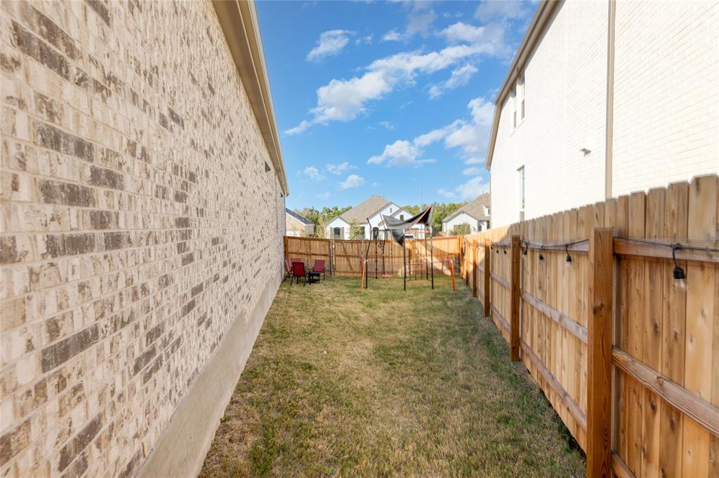 916 Willie Rnch Way Leander, TX 78641 - Photo 20 of 38 The property includes a spacious side yard with a lawn, a wood privacy fence, and a brick exterior wall