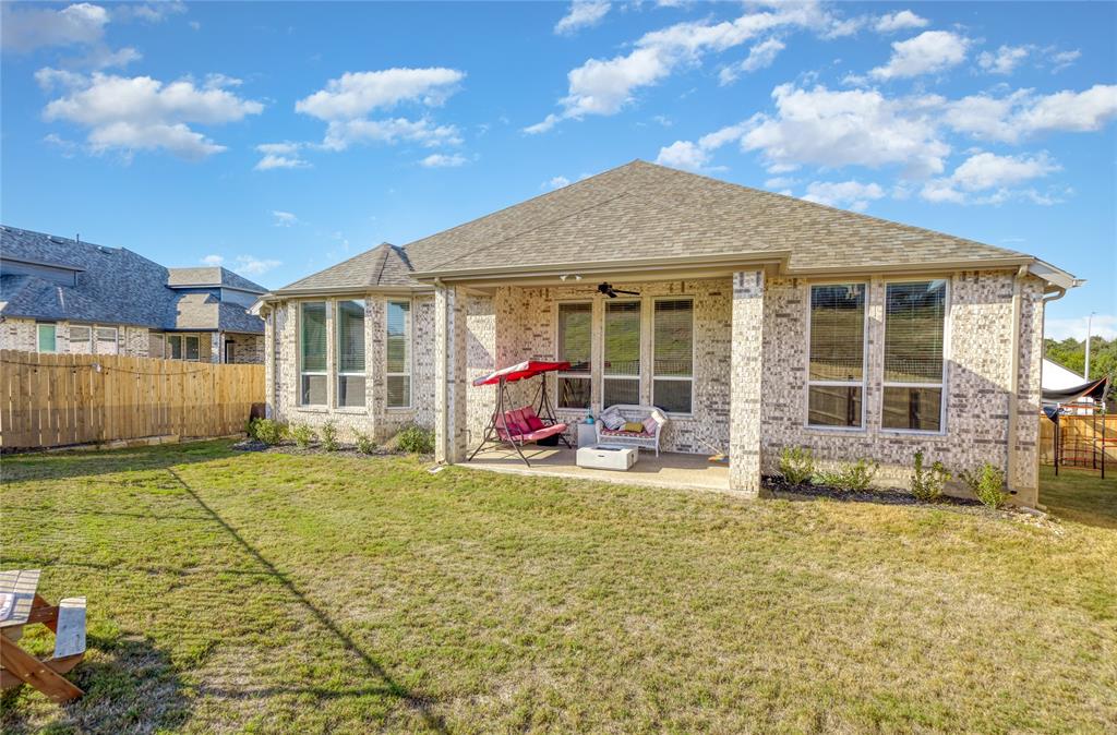 916 Willie Rnch Way Leander, TX 78641 - Photo 33 of 38 The property features a brick exterior, a covered patio, and an extensive yard with a wooden fence