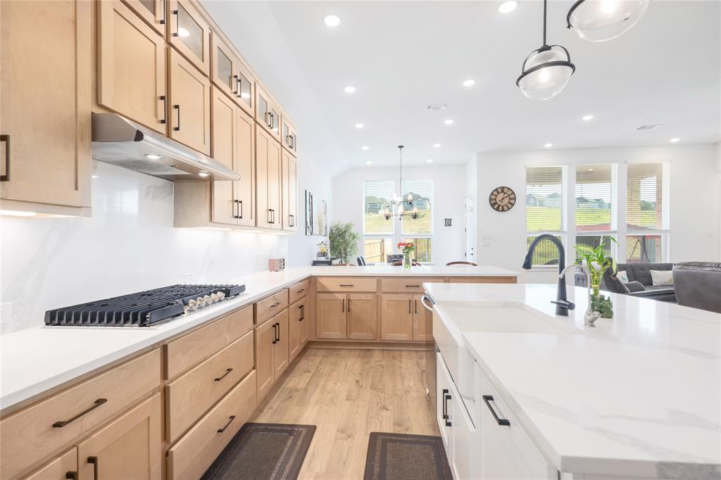 916 Willie Rnch Way Leander, TX 78641 - Photo 8 of 38 Modern kitchen featuring light wood cabinetry, white countertops, a gas cooktop, and an island with a sink
