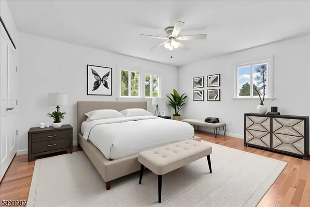 a spacious bedroom with a bed a couch and paintings on the wall