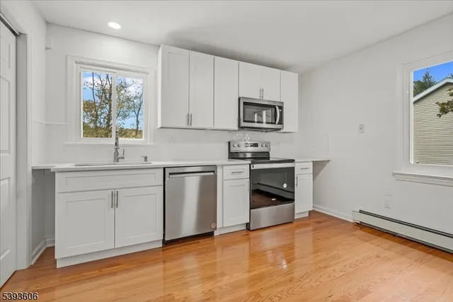 a kitchen with white cabinets and appliances